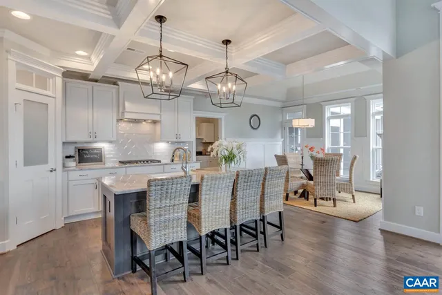a view of a dining room and livingroom with furniture wooden floor a chandelier