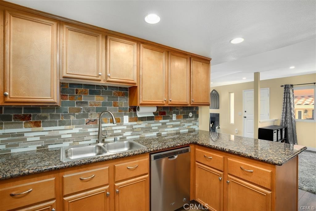 31909 Del Cielo, Unit 11 Bonsall, CA 92003 - Photo 6 of 16 a kitchen with granite countertop stainless steel appliances a sink window and cabinets