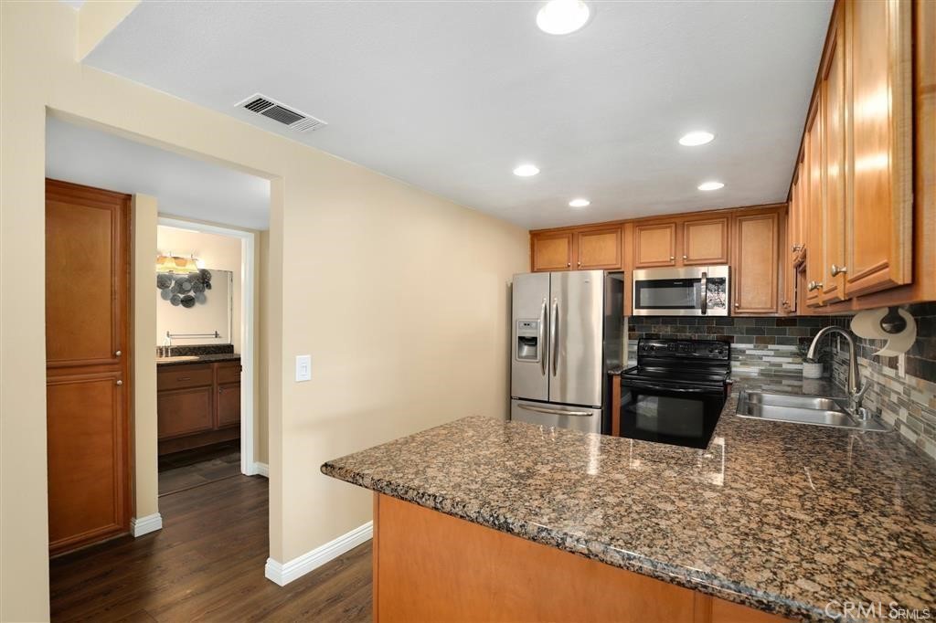 31909 Del Cielo, Unit 11 Bonsall, CA 92003 - Photo 9 of 16 a kitchen with stainless steel appliances granite countertop a refrigerator a stove a sink and a granite counter tops