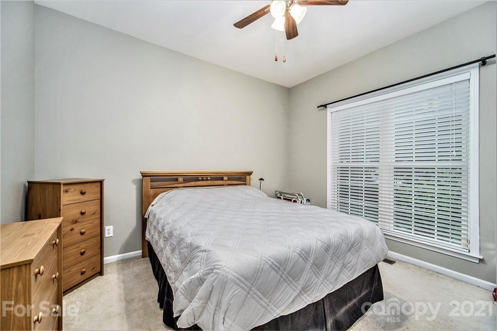 17005 Hampton Trace Road Huntersville, NC 28078 - Photo 23 of 40 a bedroom with a bed and a chandelier
