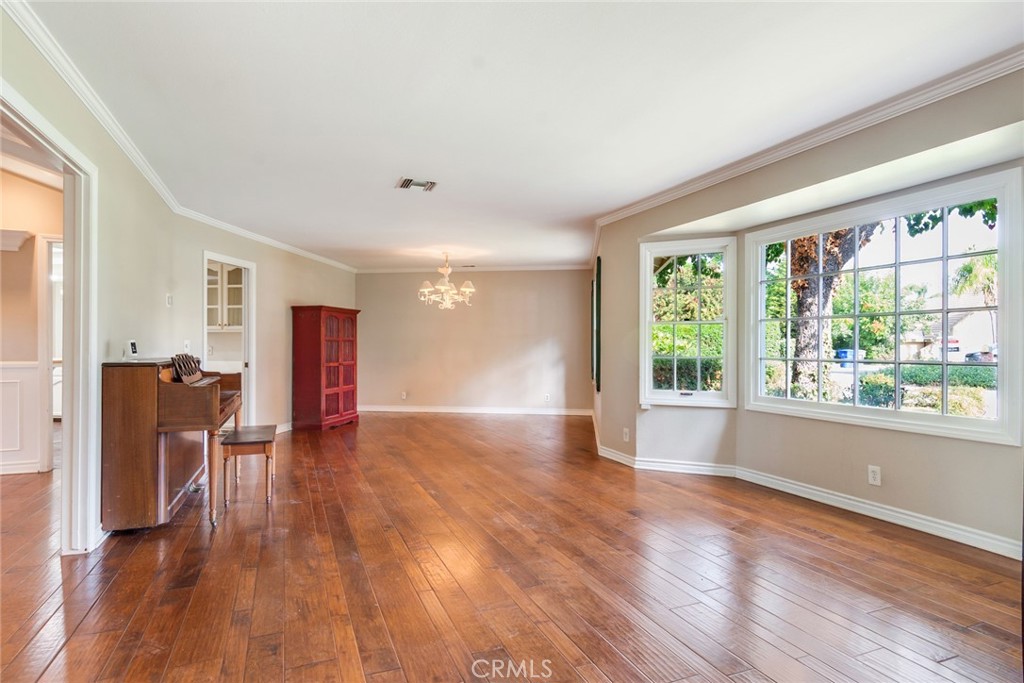 7770 Broadacre Place Riverside, CA 92504 - Photo 4 of 42 a view of an empty room with wooden floor and a window