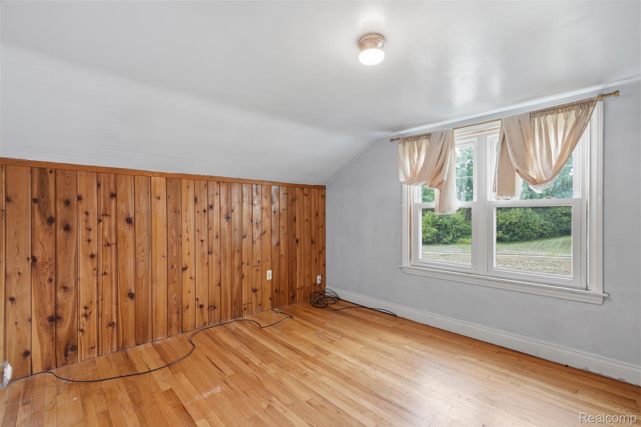 31000 Drake Road Farmington, MI 48331 - Photo 18 of 44 Hardwood flooring throughout featuring a wood-paneled accent wall
