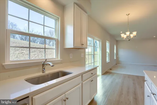 a kitchen with granite countertop white cabinets and stainless steel appliances