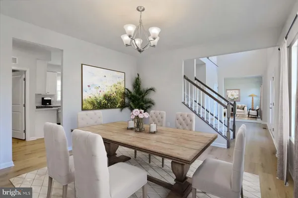 a dining room with furniture a chandelier and wooden floor