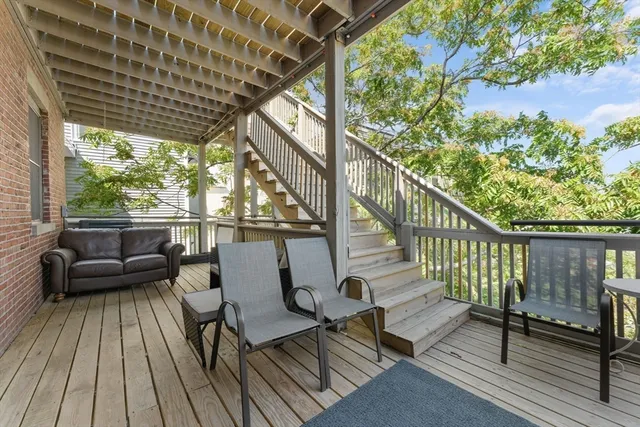 a balcony with wooden floor and outdoor seating