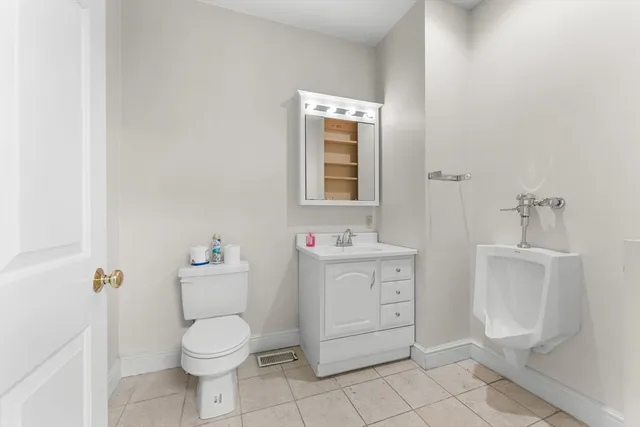 a bathroom with a toilet sink and mirror