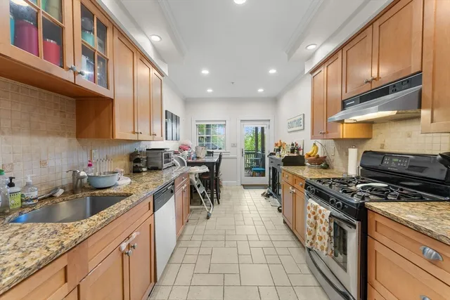 a kitchen with stainless steel appliances granite countertop a sink stove and cabinets