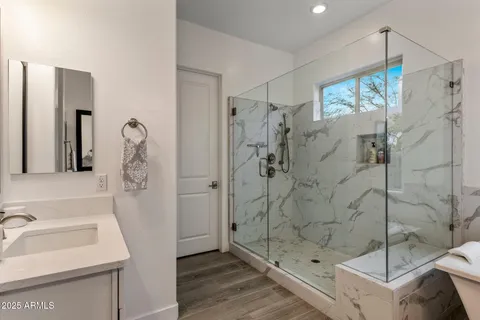 a bathroom with a sink shower and a mirror