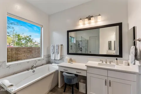 a bathroom with a tub a sink and mirror