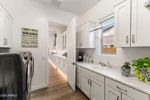 a kitchen with stainless steel appliances granite countertop a refrigerator a sink and white cabinets