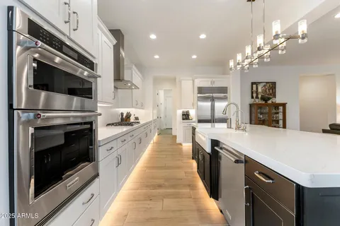 a large kitchen with stainless steel appliances kitchen island a large counter tops and a stove