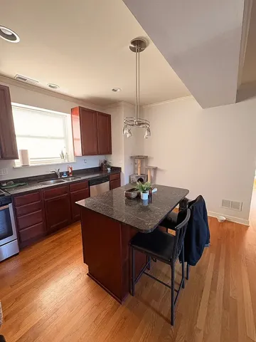 a kitchen with granite countertop a sink cabinets and wooden floor