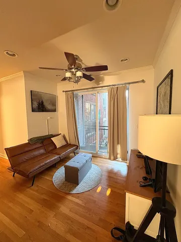a living room with a flat screen tv furniture and a window