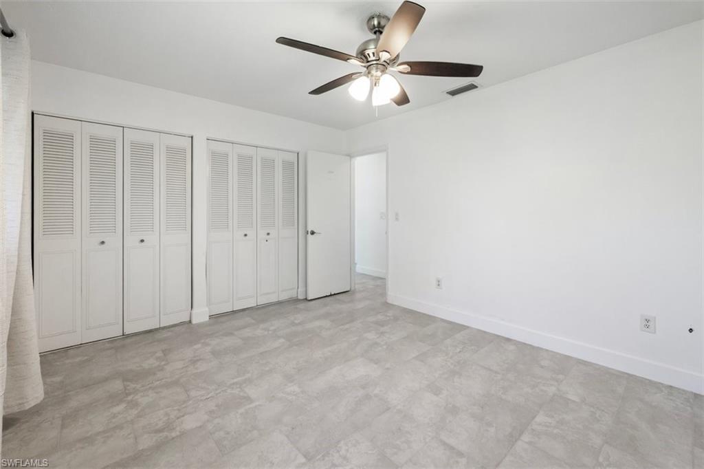 1948 46th Street Southwest Naples, FL 34116 - Photo 14 of 42 Unfurnished bedroom with two closets and a ceiling fan