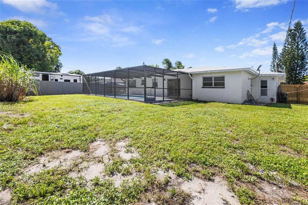 1948 46th Street Southwest Naples, FL 34116 - Photo 34 of 42 Back of property with a fenced backyard, a lanai, a sunroom, a pool, and stucco siding