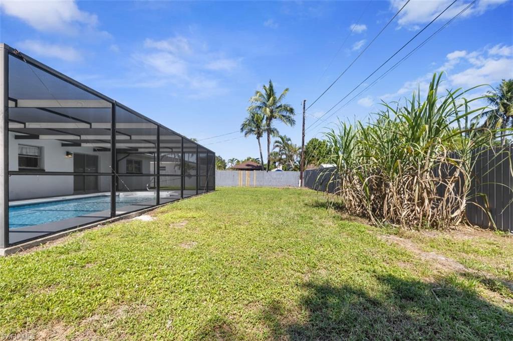 1948 46th Street Southwest Naples, FL 34116 - Photo 36 of 42 Fenced backyard with a sunroom, glass enclosure, and an outdoor pool