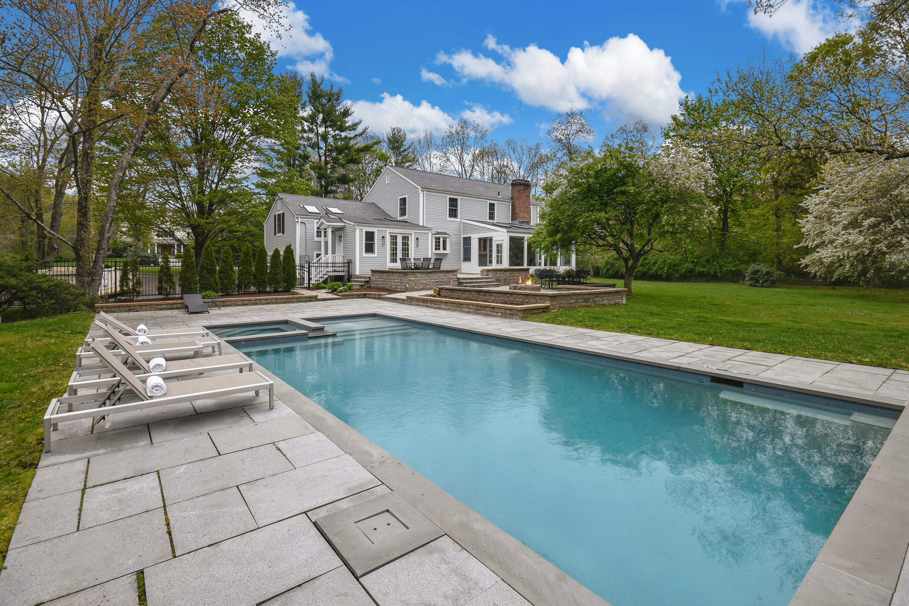 87 Juniper Road New Canaan, CT 06840 - Photo 4 of 28 a view of swimming pool that has lawn chairs with plants and trees