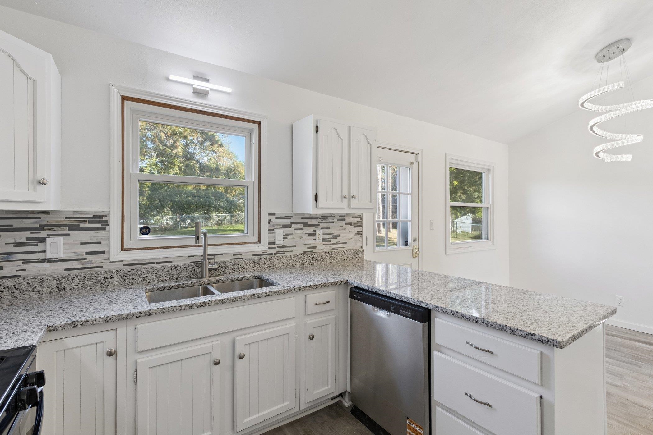 2724 Norway Pine Road Rockford, IL 61109 - Photo 12 of 49 a kitchen with granite countertop kitchen island white cabinets and a window