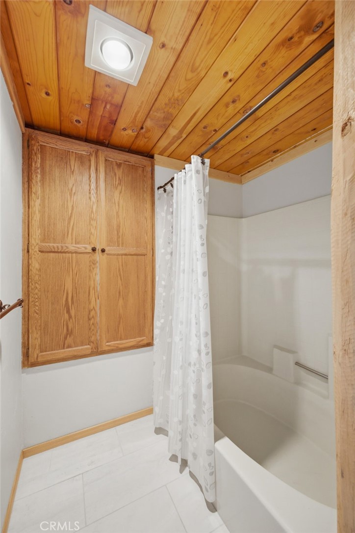 33052 Donner Lane Running Springs, CA 92382 - Photo 21 of 36 a bathroom with a bathtub and shower