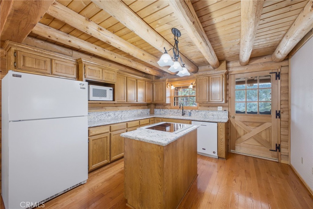33052 Donner Lane Running Springs, CA 92382 - Photo 9 of 36 a kitchen with stainless steel appliances granite countertop a sink a stove top oven a counter space and cabinets