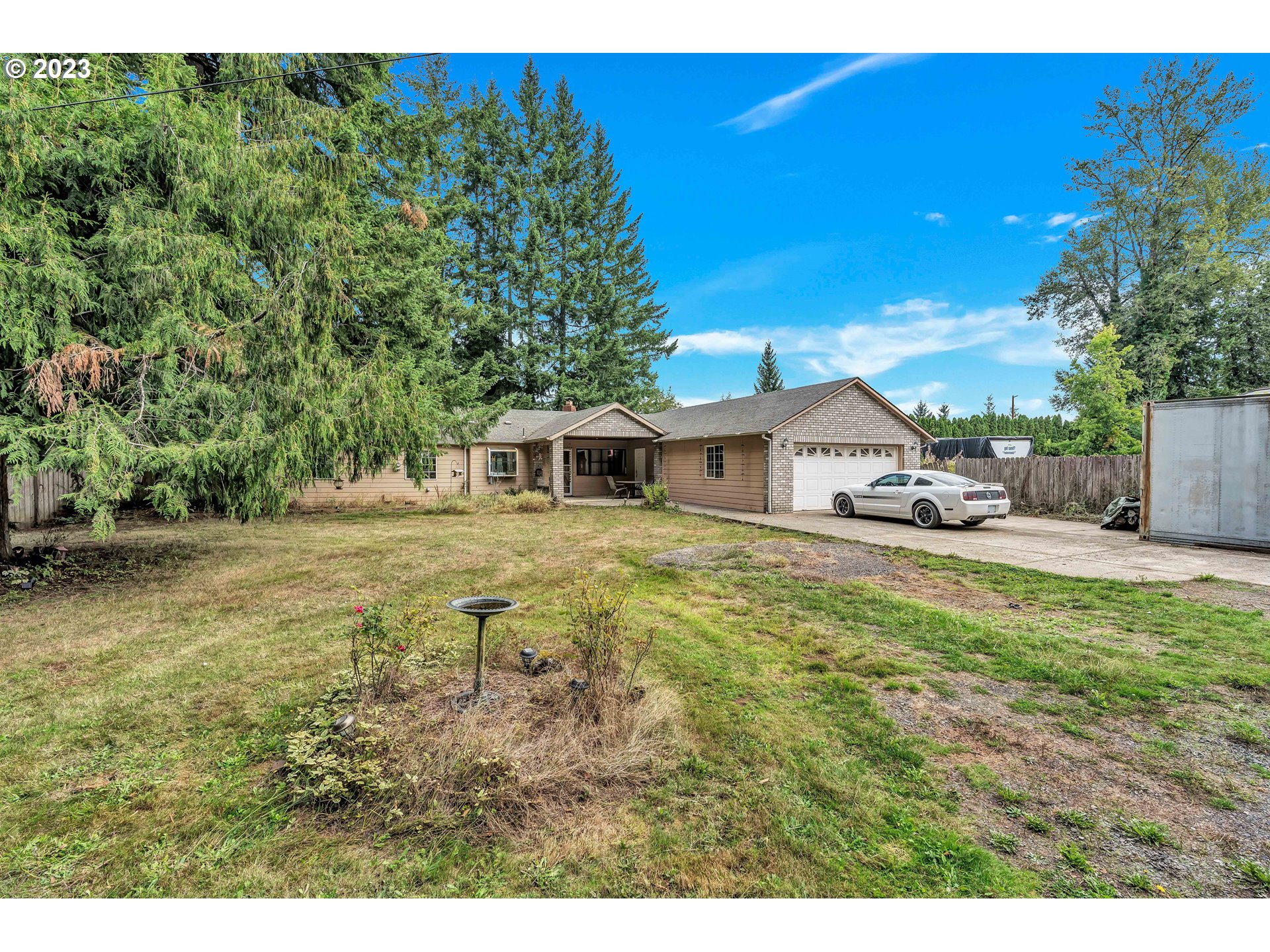47431 Southeast Wagoneer Loop Sandy, OR 97055 - Photo 2 of 34 a white house with a big yard plants and large trees