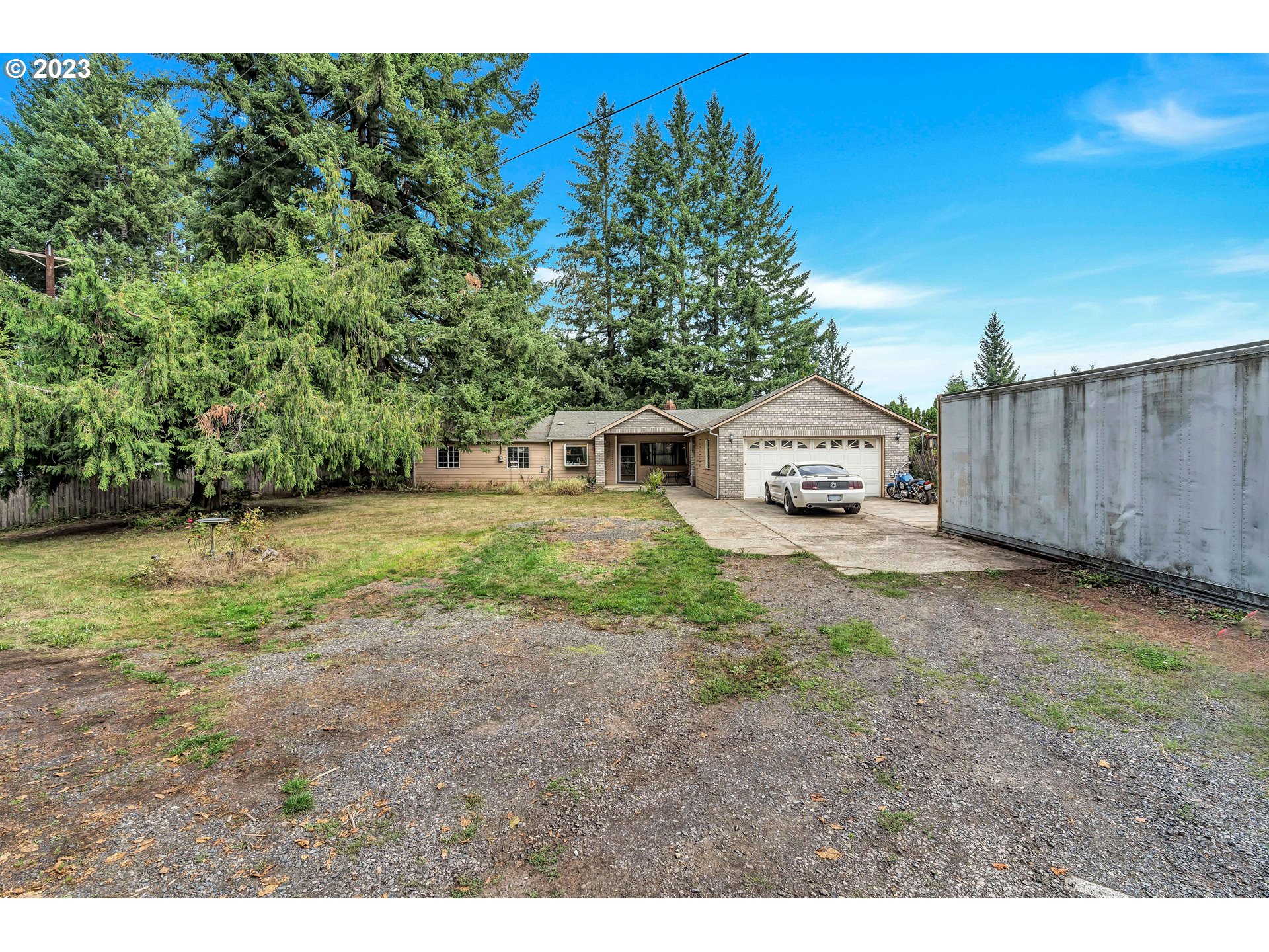 47431 Southeast Wagoneer Loop Sandy, OR 97055 - Photo 3 of 34 a view of a backyard with large trees and wooden fence