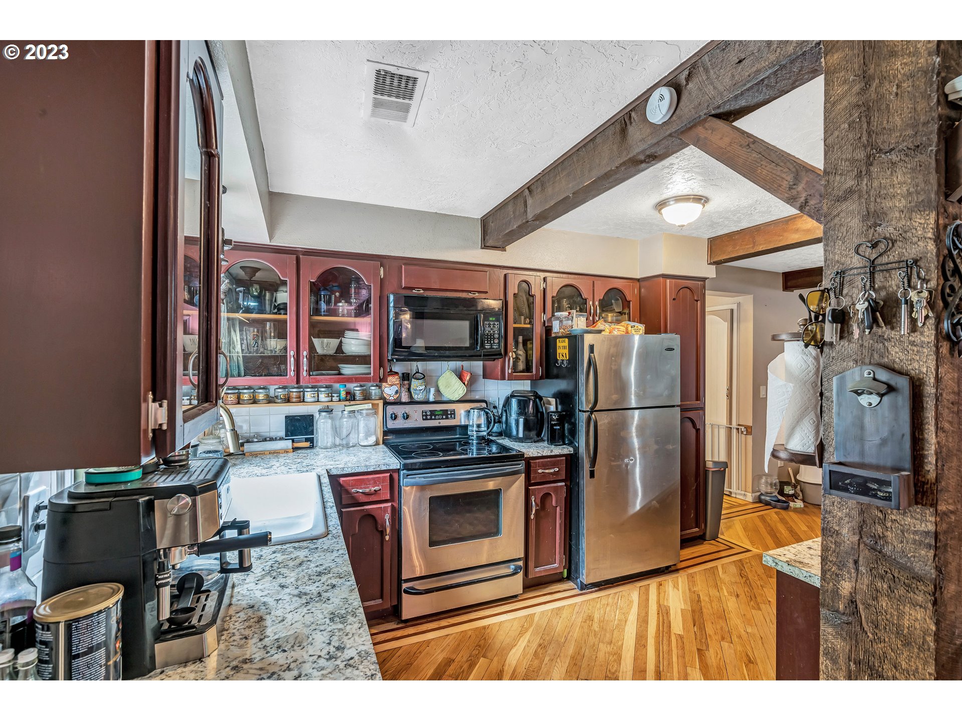 47431 Southeast Wagoneer Loop Sandy, OR 97055 - Photo 10 of 34 a kitchen with stainless steel appliances kitchen island granite countertop a table chairs and a refrigerator