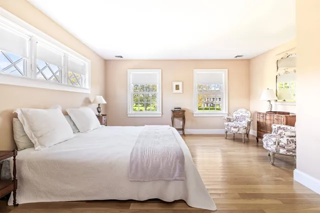 a spacious bedroom with a bed a couch and a large window