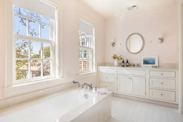 a bathroom with a granite countertop sink mirror and a bathtub