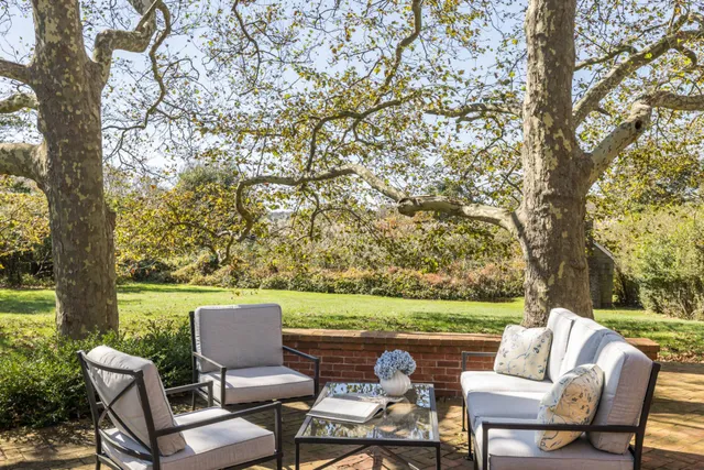 a view of a house with backyard and sitting area
