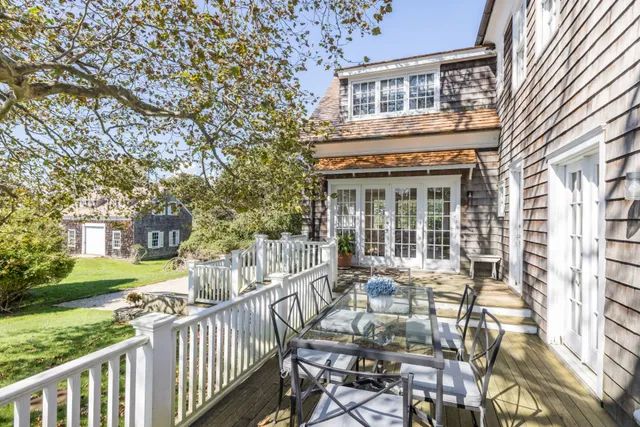 a front view of house with yard and trees in the background