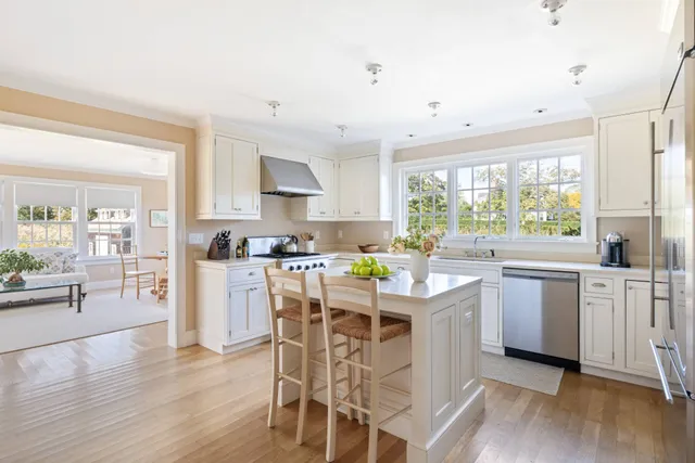 a kitchen with white cabinets and wooden floor