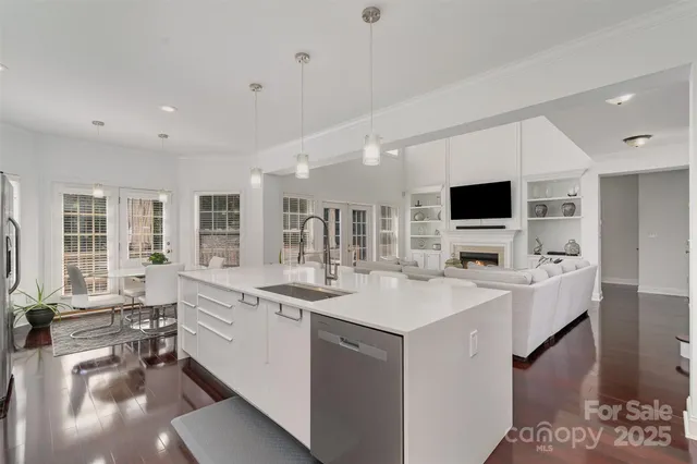 a large white kitchen with a sink and a stove top oven
