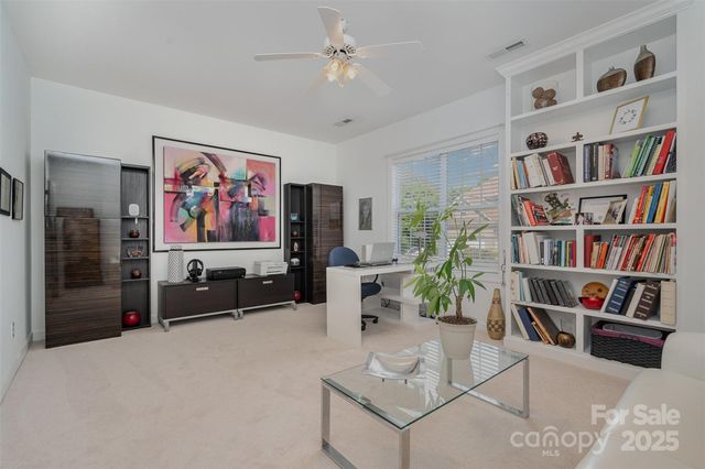 a living room with furniture a bookshelf and a flat screen tv
