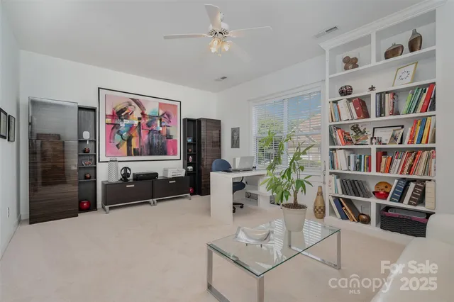 a living room with furniture a bookshelf and a flat screen tv