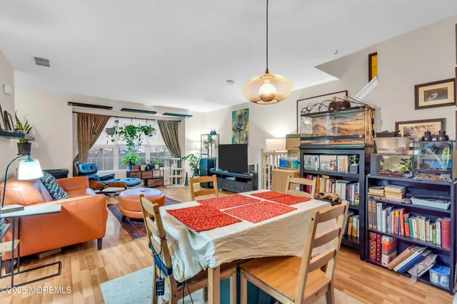 a very nice looking living room with a large dining table and a bookshelf