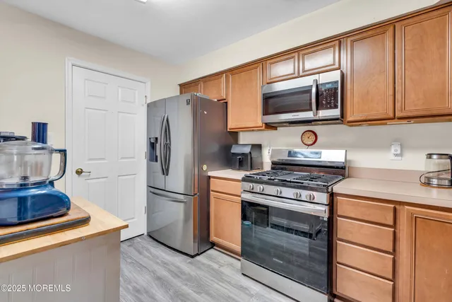 a kitchen with stainless steel appliances granite countertop a stove microwave and refrigerator