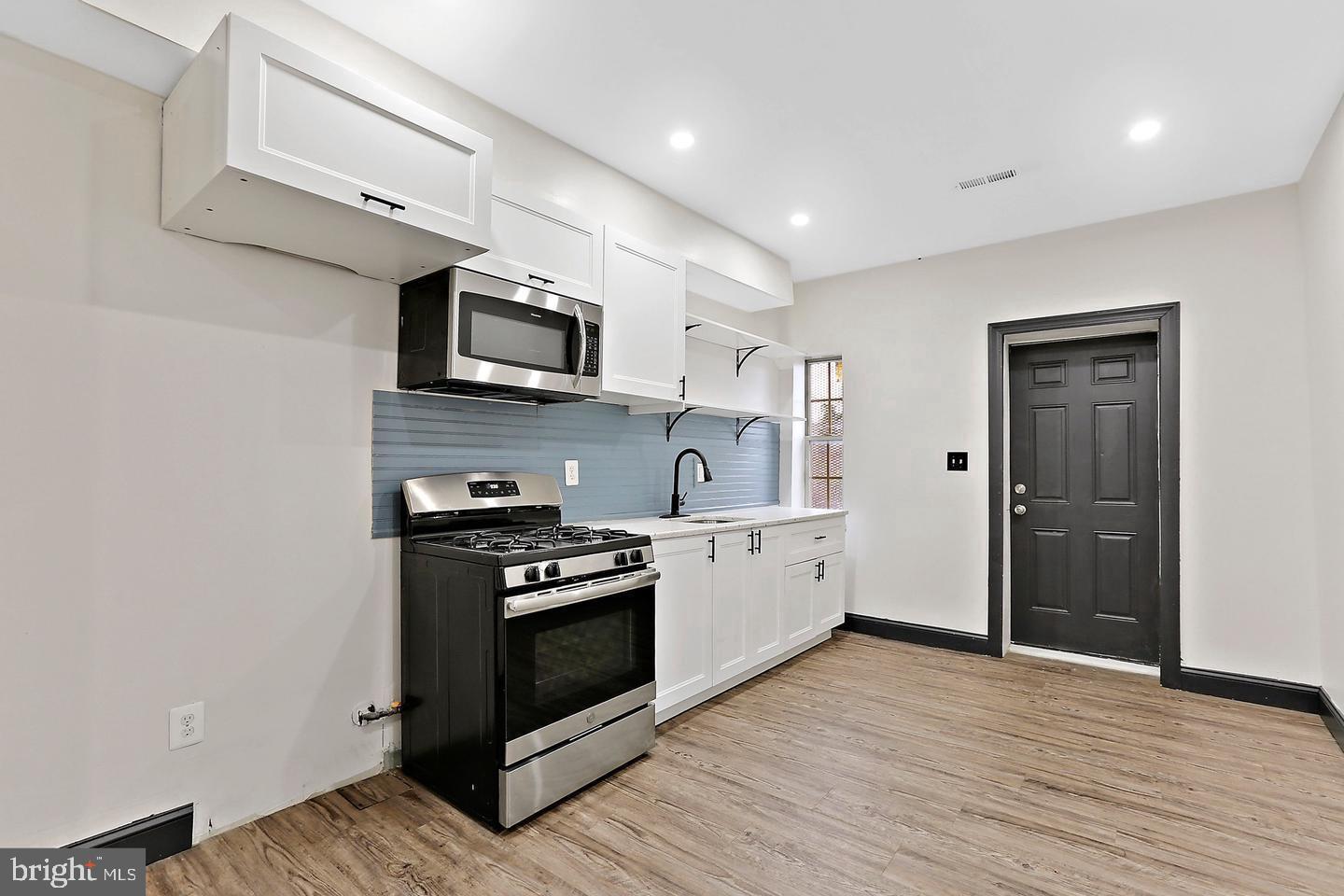 1732 McCulloh Street Baltimore, MD 21217 - Photo 14 of 30 a kitchen with stainless steel appliances granite countertop a stove a sink and a microwave