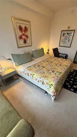 a bedroom with a bed and painting on the wall