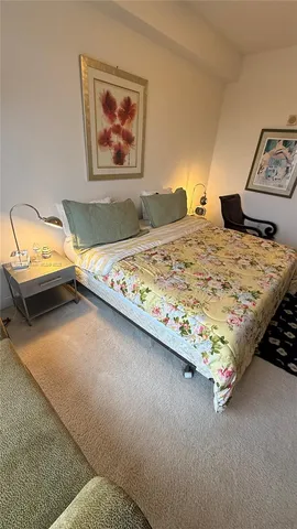 a bedroom with a bed and painting on the wall