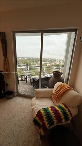a living room with furniture and a floor to ceiling window