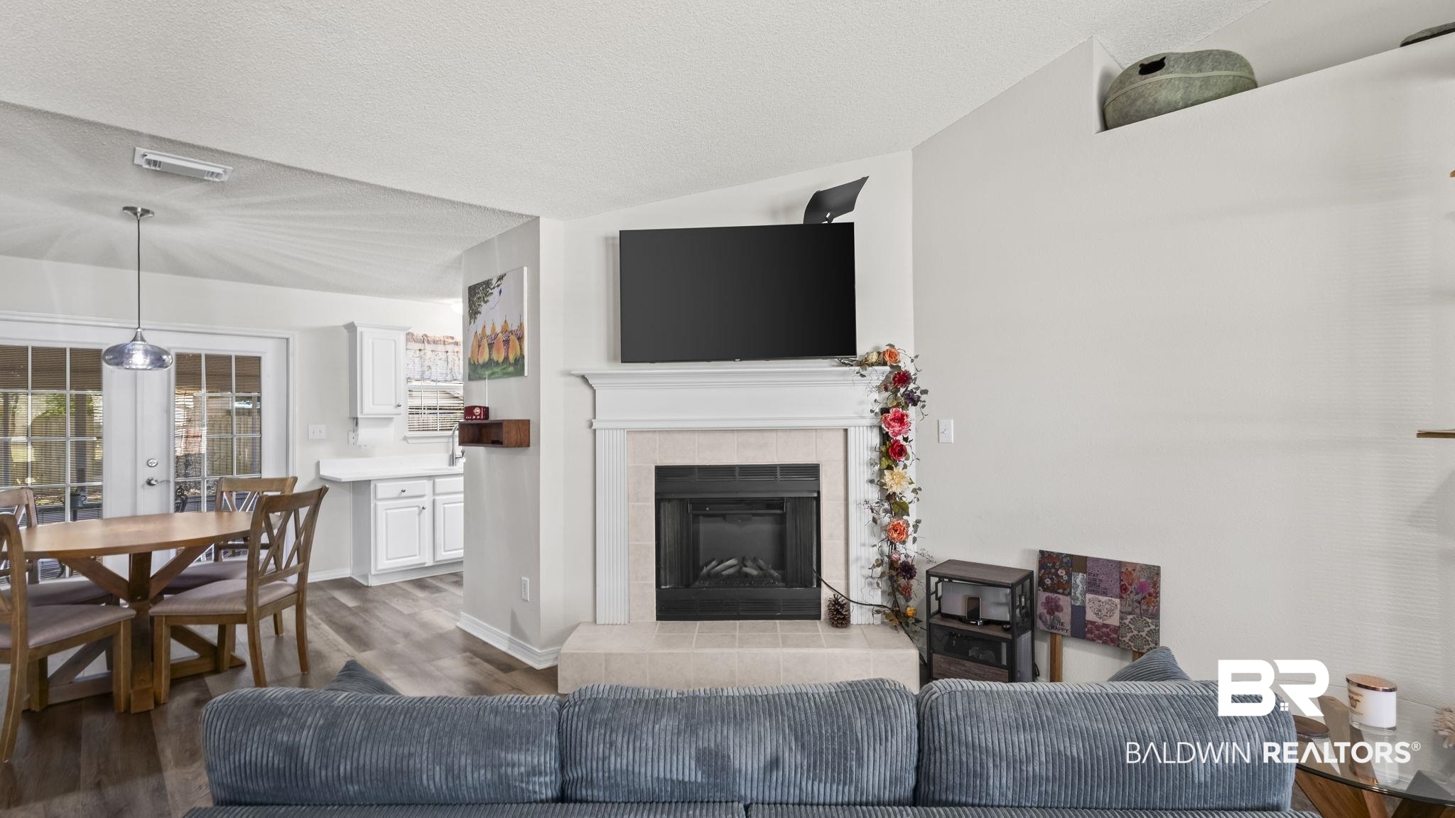 302 Cluster Street Foley, AL 36535 - Photo 11 of 28 Living area with a tiled fireplace, wood finished floors, a textured ceiling, and french doors