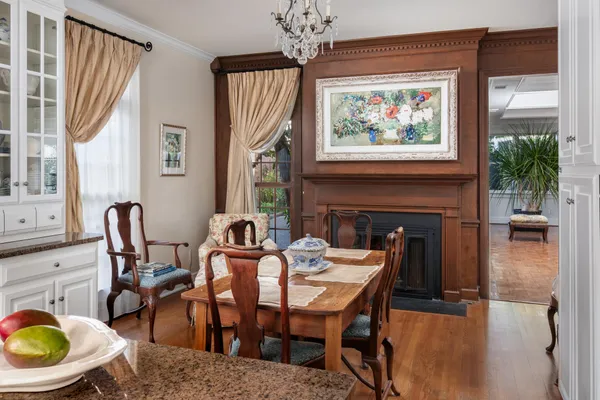 a dining room with furniture a fireplace and wooden floor
