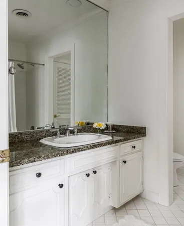 a bathroom with a granite countertop sink and a mirror