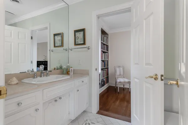 a en suite bathroom with a granite countertop sink and a mirror