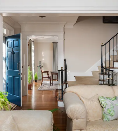 a living room with couches and dining table with wooden floor