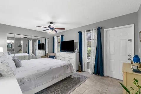 a bedroom with a balcony a bed and a flat screen tv