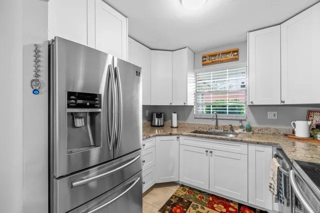 a kitchen with stainless steel appliances a refrigerator sink and cabinets