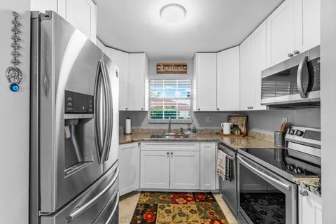 a kitchen with stainless steel appliances a stove a sink and a refrigerator