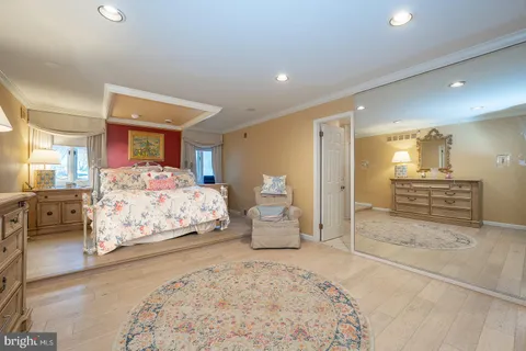 a spacious bedroom with a bed and wooden floor